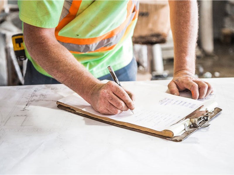 worker writing in book