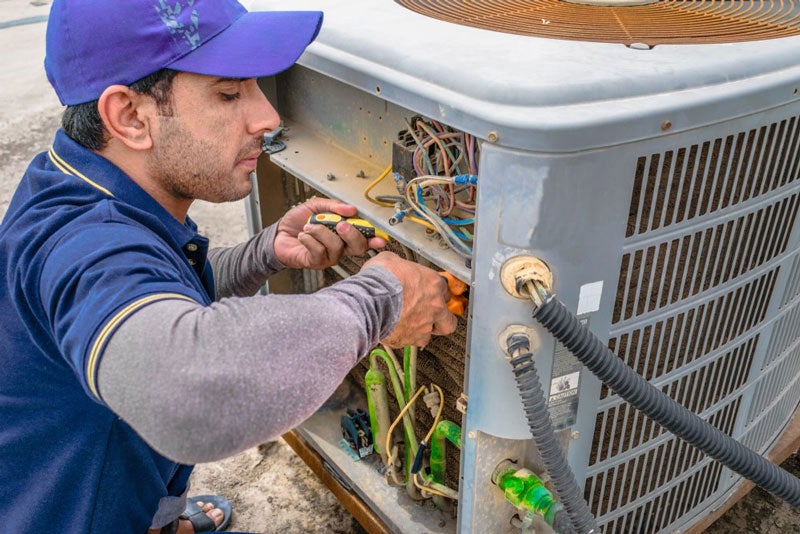 technician repairing AC unit