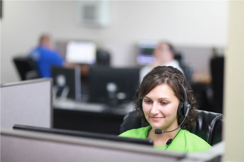 woman sitting at desk wearing a headset