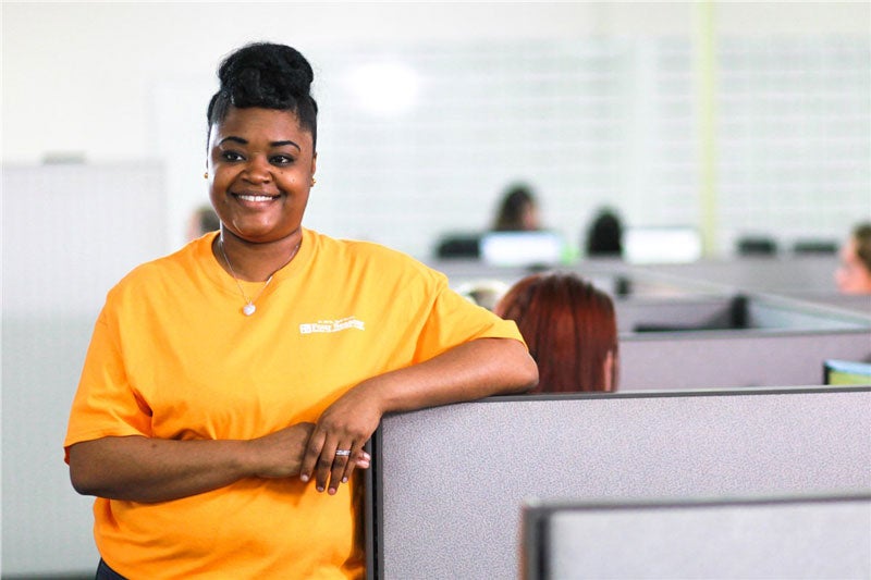 smiling woman in cubicle