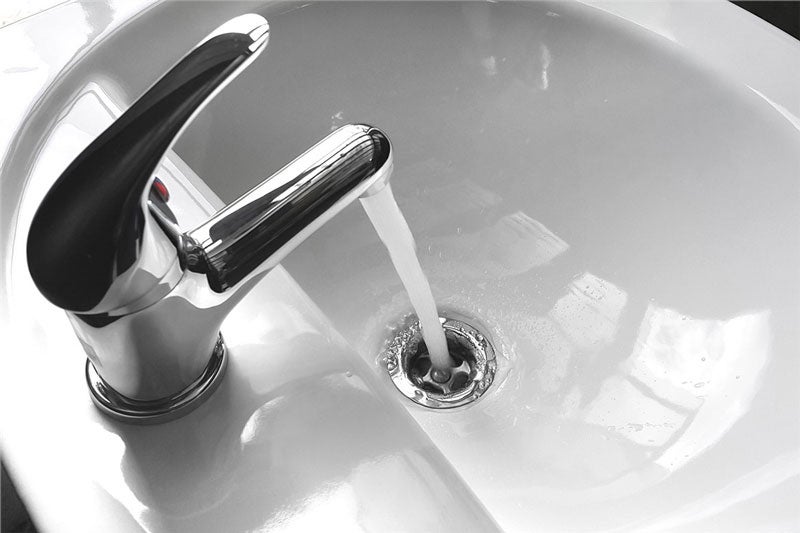 water flowing out of faucet into sink