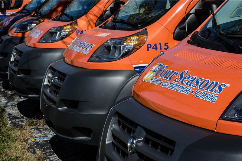 line of Four Seasons vans from the front