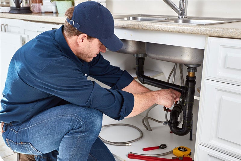 plumber working under kitchen sink