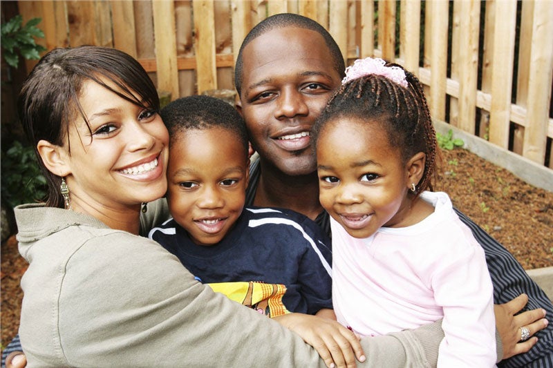 family smiling in backyard